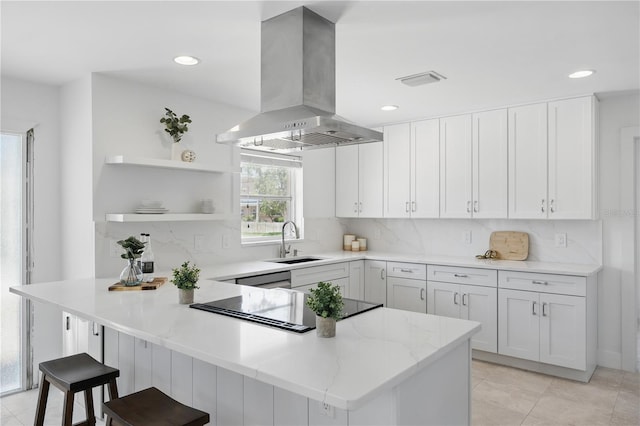 3528 Casablanca Ave, Saint Petersburg, FL 33706 - kitchen with island exhaust hood, a sink, a peninsula, white cabinetry, and decorative backsplash