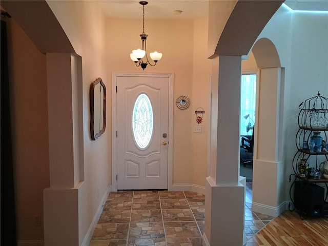 2474 Cimmaron Ash Way, Apopka, FL 32703 - foyer with arched walkways, a chandelier, stone finish floors, baseboards, and a towering ceiling