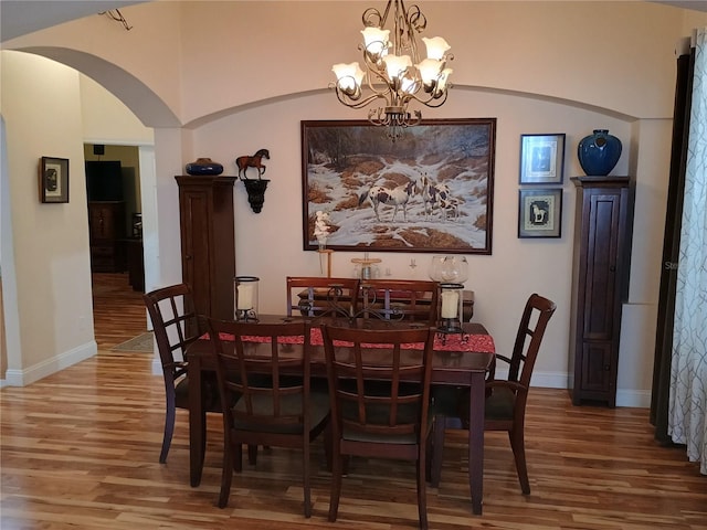 2474 Cimmaron Ash Way, Apopka, FL 32703 - dining space featuring wood finished floors, arched walkways, a chandelier, and baseboards