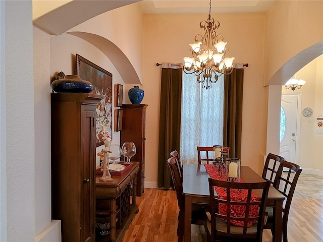 2474 Cimmaron Ash Way, Apopka, FL 32703 - dining space featuring arched walkways, a chandelier, and light wood finished floors