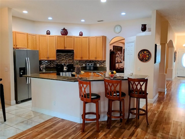2474 Cimmaron Ash Way, Apopka, FL 32703 - kitchen with stainless steel fridge, arched walkways, range, dark countertops, and recessed lighting