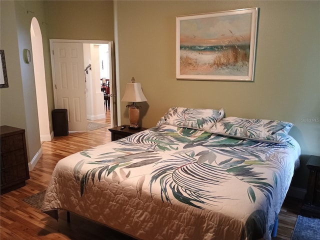 2474 Cimmaron Ash Way, Apopka, FL 32703 - bedroom with arched walkways, wood finished floors, and baseboards