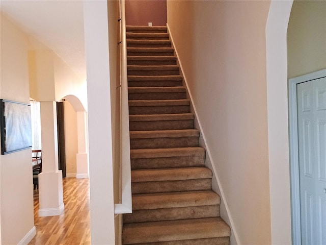 2474 Cimmaron Ash Way, Apopka, FL 32703 - stairs with arched walkways, wood finished floors, and baseboards