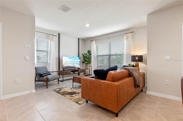 5625 Brosnan Rd, Saint Cloud, FL 34771 - living room with healthy amount of natural light, baseboards, light tile patterned flooring, and a textured ceiling