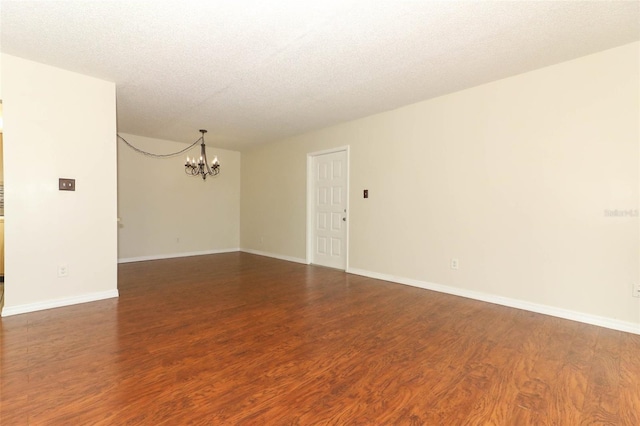 1221 S Pine Ridge Cir Unit A2, Sanford, FL 32773 - empty room featuring a chandelier, dark wood-style flooring, a textured ceiling, and baseboards