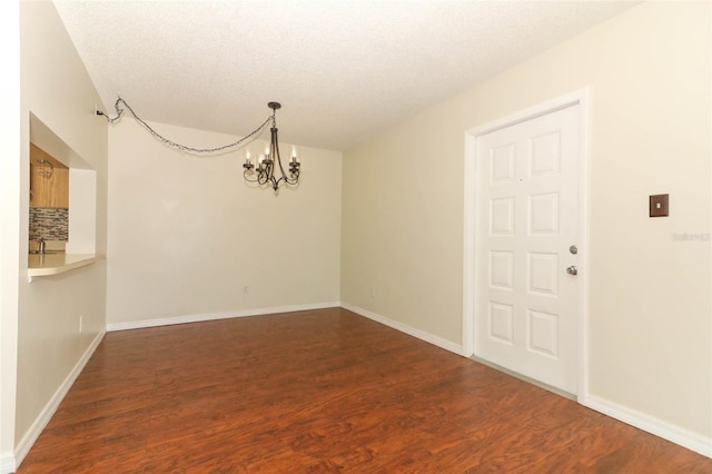 1221 S Pine Ridge Cir Unit A2, Sanford, FL 32773 - unfurnished dining area with a chandelier, wood finished floors, baseboards, a textured ceiling, and a sink
