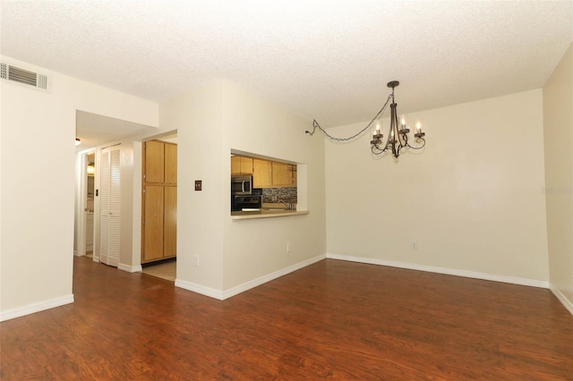 1221 S Pine Ridge Cir Unit A2, Sanford, FL 32773 - spare room featuring a chandelier, wood finished floors, a textured ceiling, and baseboards