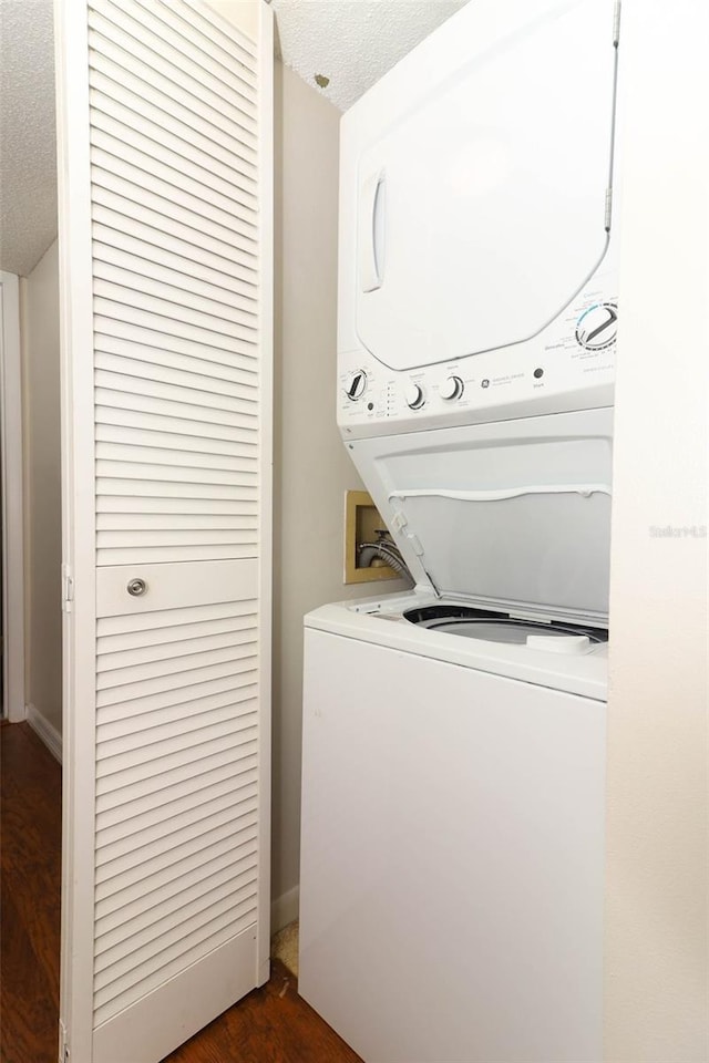 1221 S Pine Ridge Cir Unit A2, Sanford, FL 32773 - laundry room featuring stacked washing machine and dryer, dark wood finished floors, and a textured ceiling