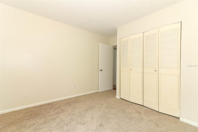 1221 S Pine Ridge Cir Unit A2, Sanford, FL 32773 - unfurnished bedroom with light carpet, a closet, baseboards, and a textured ceiling