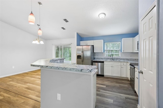 395 Alcazar Ave, De Leon Springs, FL 32130 - kitchen featuring stainless steel appliances, a sink, a center island, white cabinets, and a chandelier