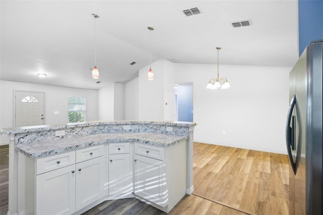 395 Alcazar Ave, De Leon Springs, FL 32130 - kitchen with freestanding refrigerator, light wood-type flooring, a chandelier, white cabinets, and light stone counters