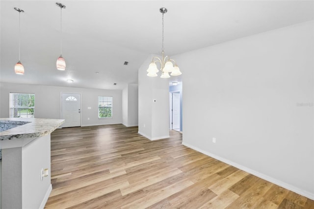 395 Alcazar Ave, De Leon Springs, FL 32130 - unfurnished dining area featuring light wood-style floors, a chandelier, vaulted ceiling, and baseboards