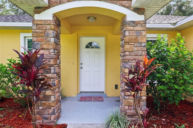 395 Alcazar Ave, De Leon Springs, FL 32130 - doorway to property with stucco siding, stone siding, and a shingled roof