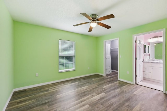 395 Alcazar Ave, De Leon Springs, FL 32130 - unfurnished bedroom with wood finished floors, a spacious closet, baseboards, a closet, and ensuite bath