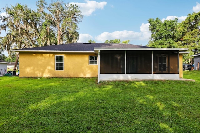 395 Alcazar Ave, De Leon Springs, FL 32130 - back of property featuring a sunroom, stucco siding, and a yard