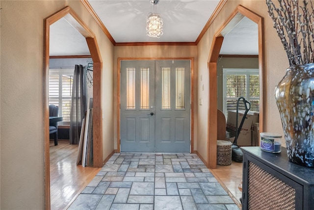 616 Magnolia St, Windermere, FL 34786 - entryway with ornamental molding, arched walkways, a textured wall, and light stone finish flooring
