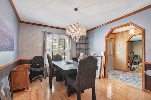 616 Magnolia St, Windermere, FL 34786 - dining area with light wood-style floors, a chandelier, ornamental molding, and arched walkways