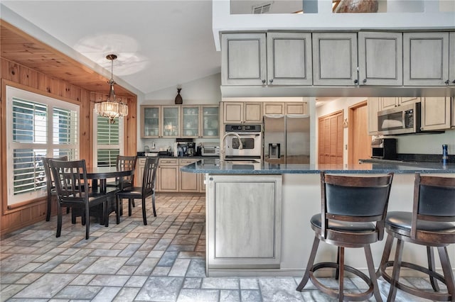 616 Magnolia St, Windermere, FL 34786 - kitchen featuring appliances with stainless steel finishes, lofted ceiling, glass insert cabinets, a chandelier, and hanging light fixtures