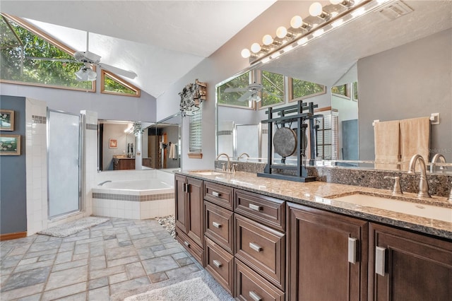 616 Magnolia St, Windermere, FL 34786 - full bathroom featuring double vanity, ceiling fan, a bath, stone tile floors, and lofted ceiling