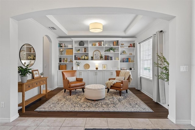 15318 Sandfield Loop, Winter Garden, FL 34787 - living area featuring arched walkways, wood finished floors, a raised ceiling, ornamental molding, and built in shelves