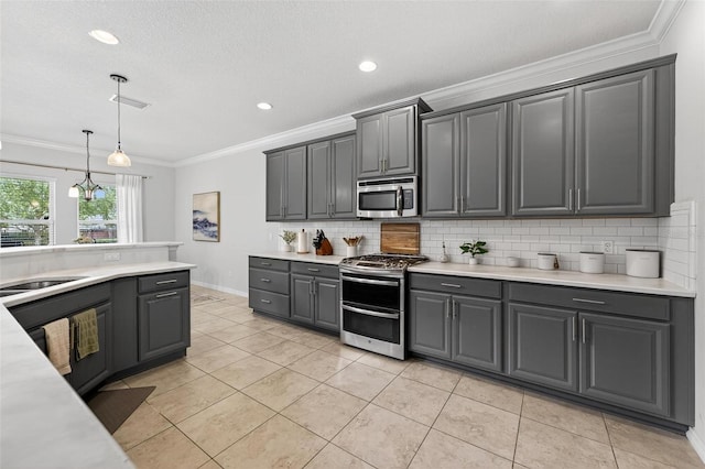 15318 Sandfield Loop, Winter Garden, FL 34787 - kitchen with appliances with stainless steel finishes, gray cabinetry, tasteful backsplash, light countertops, and ornamental molding