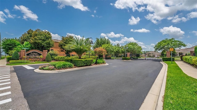15318 Sandfield Loop, Winter Garden, FL 34787 - view of asphalt street with sidewalks, curbs, a gated entry, and traffic signs