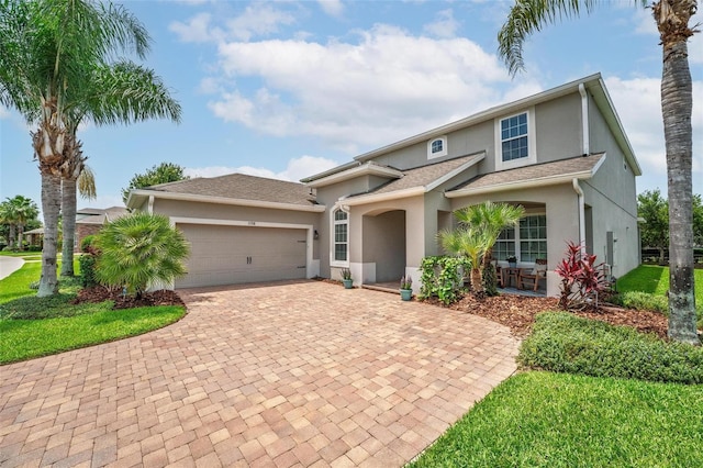 15318 Sandfield Loop, Winter Garden, FL 34787 - traditional-style home with stucco siding, decorative driveway, an attached garage, and a front lawn