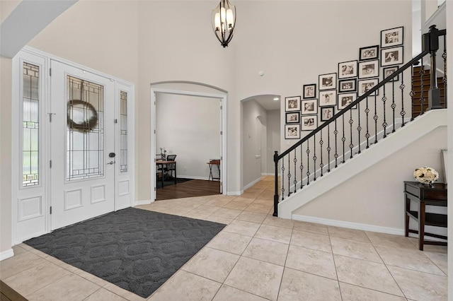 15318 Sandfield Loop, Winter Garden, FL 34787 - tiled foyer entrance with arched walkways, a high ceiling, stairway, and baseboards