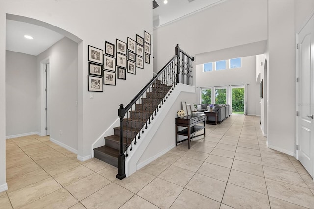 15318 Sandfield Loop, Winter Garden, FL 34787 - stairway with tile patterned floors, arched walkways, baseboards, a high ceiling, and recessed lighting