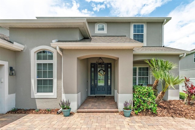 15318 Sandfield Loop, Winter Garden, FL 34787 - doorway to property featuring stucco siding and a shingled roof