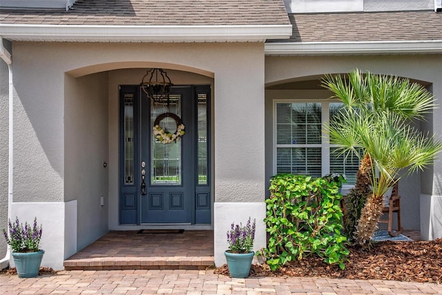 15318 Sandfield Loop, Winter Garden, FL 34787 - view of exterior entry featuring a shingled roof and stucco siding