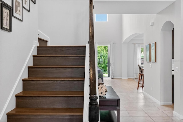 15318 Sandfield Loop, Winter Garden, FL 34787 - stairway with arched walkways, tile patterned flooring, baseboards, and a towering ceiling