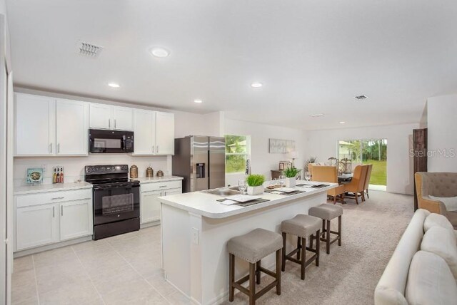 8624 N Pitcairn Way, Citrus Springs, FL 34434 - kitchen with black appliances, a breakfast bar, light countertops, white cabinetry, and recessed lighting