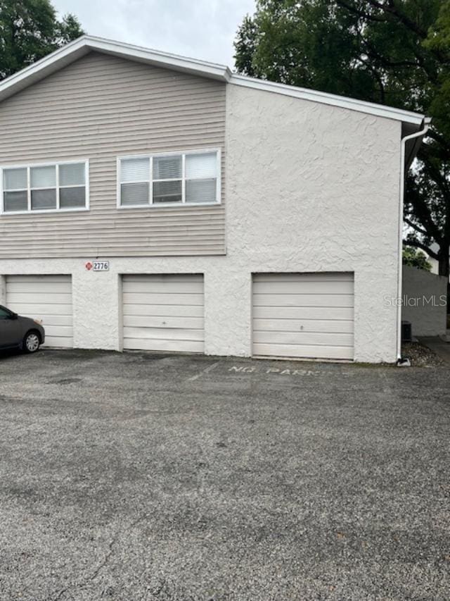 2776 Curry Ford Rd Ge, Unit Ge, Orlando, FL 32806 - view of home's exterior with a garage, stucco siding, and driveway