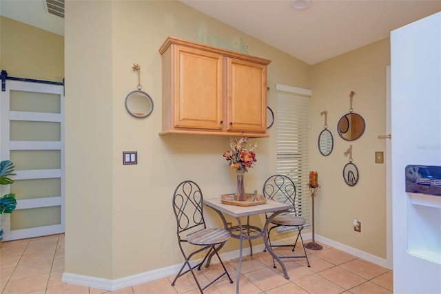 5323 Concord Way, Fort Myers, FL 33907 - dining area featuring a barn door, light tile patterned floors, and baseboards