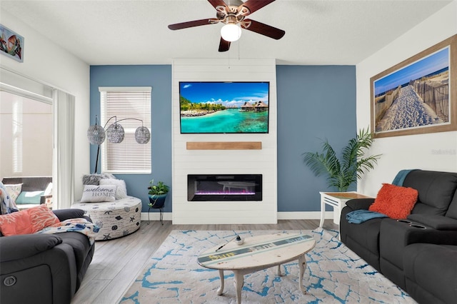 15613 Camp Dubois Cres, Winter Garden, FL 34787 - living area featuring ceiling fan, wood finished floors, a fireplace, baseboards, and a textured ceiling