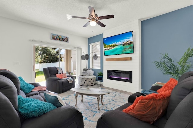 15613 Camp Dubois Cres, Winter Garden, FL 34787 - living room with wood finished floors, ceiling fan, a large fireplace, and a textured ceiling