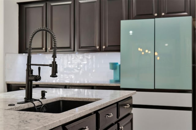 15613 Camp Dubois Cres, Winter Garden, FL 34787 - kitchen featuring freestanding refrigerator, a sink, light stone countertops, and decorative backsplash