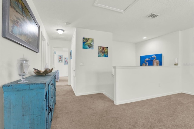 15613 Camp Dubois Cres, Winter Garden, FL 34787 - corridor featuring light carpet, attic access, an upstairs landing, baseboards, and a textured ceiling