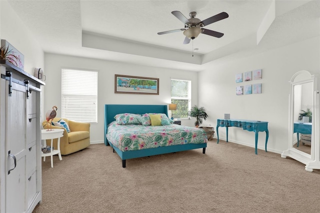 15613 Camp Dubois Cres, Winter Garden, FL 34787 - carpeted bedroom featuring a tray ceiling, a barn door, baseboards, and a ceiling fan