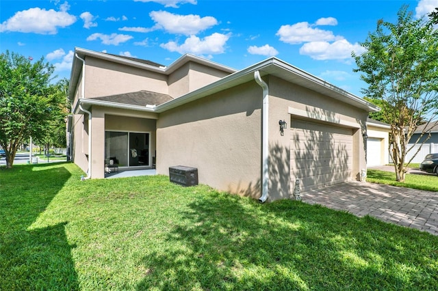 15613 Camp Dubois Cres, Winter Garden, FL 34787 - view of home's exterior with an attached garage, stucco siding, a yard, and decorative driveway