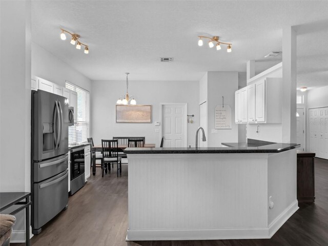 917 Dekleva Dr, Apopka, FL 32712 - kitchen featuring appliances with stainless steel finishes, a peninsula, a chandelier, white cabinets, and dark wood-style floors