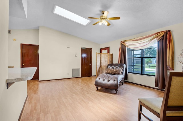 281 NE Greenbrier Ave, Port St Lucie, FL 34983 - living area with ceiling fan, light wood-style floors, a skylight, and vaulted ceiling