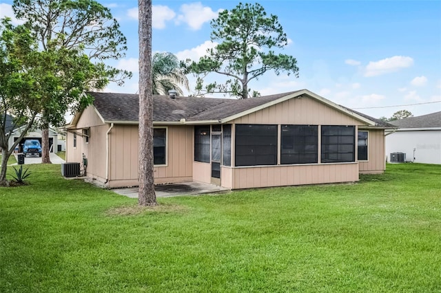 281 NE Greenbrier Ave, Port St Lucie, FL 34983 - rear view of property with a sunroom, a lawn, and roof with shingles