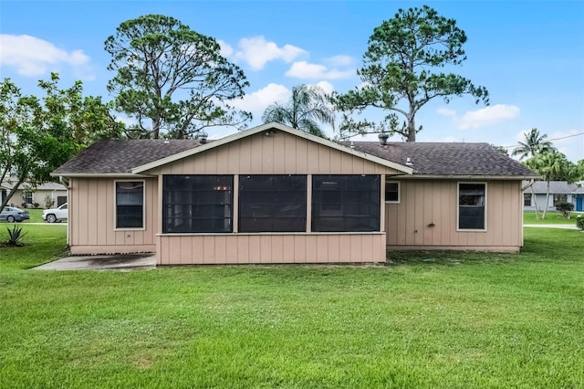 281 NE Greenbrier Ave, Port St Lucie, FL 34983 - back of property with a yard, a sunroom, and a shingled roof