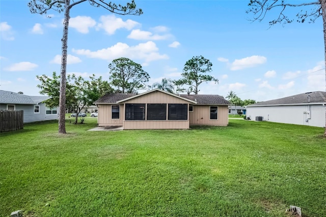 281 NE Greenbrier Ave, Port St Lucie, FL 34983 - back of house with a sunroom, a yard, and roof with shingles