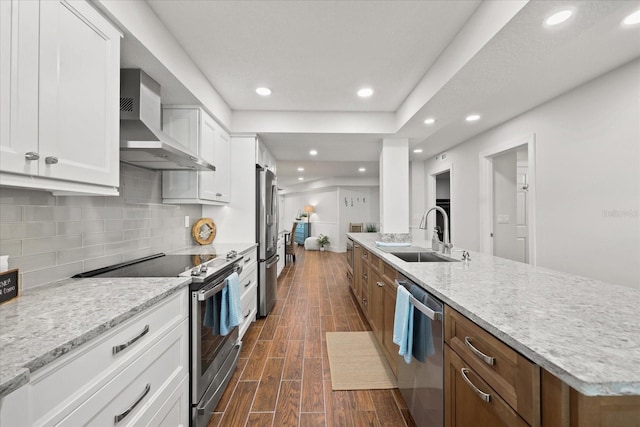 4621 S Atlantic Ave Unit 7202, Port Orange, FL 32127 - kitchen featuring a sink, stainless steel appliances, wall chimney range hood, dark wood-style floors, and white cabinets