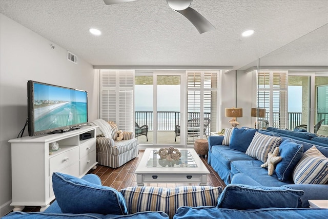 4621 S Atlantic Ave Unit 7202, Port Orange, FL 32127 - living room with a textured ceiling, dark wood-style floors, plenty of natural light, and a ceiling fan