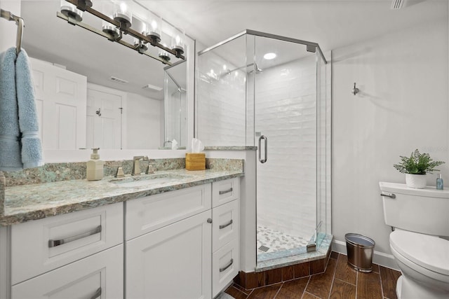 4621 S Atlantic Ave Unit 7202, Port Orange, FL 32127 - full bathroom featuring vanity, toilet, a shower stall, wood finished floors, and baseboards