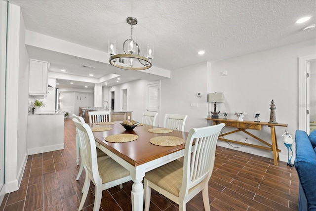 4621 S Atlantic Ave Unit 7202, Port Orange, FL 32127 - dining space featuring wood finish floors, a chandelier, baseboards, a textured ceiling, and recessed lighting